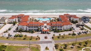 A beachfront hotel with multiple buildings, a swimming pool, and a parking area. - Oceanfront 2-bedroom condo at North Topsail Beach, perfect for family getaways. (North Topsail Beach)