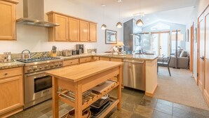 Une cuisine moderne avec des meubles en bois, des appareils en acier inoxydable et un îlot central.