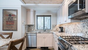 A modern kitchen with granite countertops, stainless steel appliances, and a window above the sink. - Sun Valley Village | Pool Access | Deck (Sun Valley)