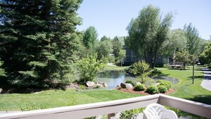A landscaped garden with a pond, trees, and a building in the background. - Sun Valley Village | Pool Access | Deck (Sun Valley)