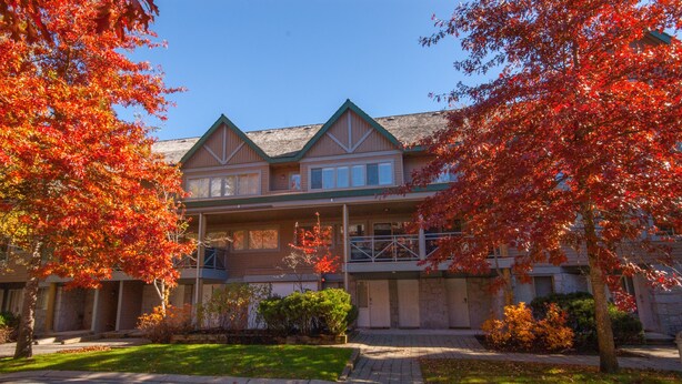 A two-story building with a symmetrical facade, a central entrance, and a covered porch.