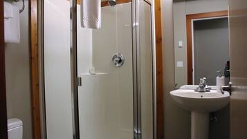Une salle de bain avec une douche à parois de verre, un lavabo et un miroir.