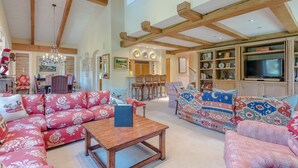 A spacious living room with high ceilings and exposed wooden beams, furnished with patterned sofas and a wooden coffee table. - Lodge Apt. II 886 - Perfect for Families Sun Valley Resort Style & Amenities (Sun Valley)