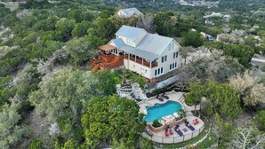 Une grande maison avec une piscine, entourée d’une végétation luxuriante.