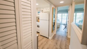 A modern kitchen with white cabinets, a refrigerator, and a microwave. - Island Escape 201 Affordable Condo (Clearwater Beach)