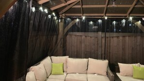 Un interior acogedor y rústico, con techo de madera y un área de estar con cojines.