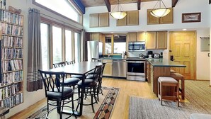 A spacious kitchen with wooden cabinets, a central island, and a dining area with a large table and chairs. - 🌲Timberline B3E Standard 2-Bedroom + Loft ~ 2/bath ~Hot Tub~Pool~WiFi~Ski-in/out🌲 (Snowmass Village)