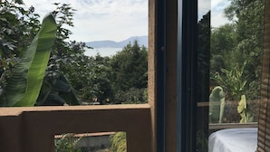 A balcony with a view of a mountain and a body of water.