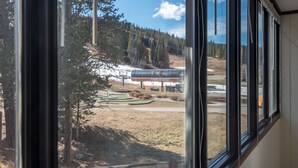 Une vue à travers la fenêtre d’un bâtiment, avec un terrain de golf et une station-service en arrière-plan.