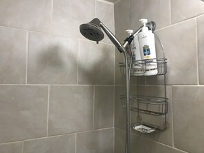 Een bad/douchecombinatie, een haardroger, handdoeken, zeep