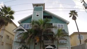 Une maison à deux étages, dotée d’un toit végétalisé et de boiseries blanches, avec le numéro « 5312 » affiché sur la façade.