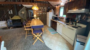 Una cocina acogedora con una mesa de madera, sillas y una estufa empotrada.