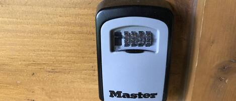 Ein Master-Marken-Schloss für elektronische Geräte auf einer Holztischplatte.