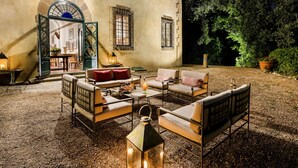 An outdoor seating area with a mix of sofas and chairs, a table with drinks, and a lantern. - Exclusive 7BR-8BA Villa with pool, a few mins from town, yet in the countryside (Impruneta)
