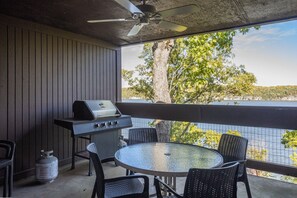 Enjoy al fresco dining with a view of the water and surrounding trees from this patio, featuring a round table and comfortable seating for four.