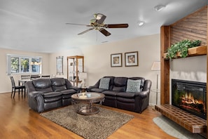 Relax in this stylish living room with a comfortable sofa, fireplace, and dining area.