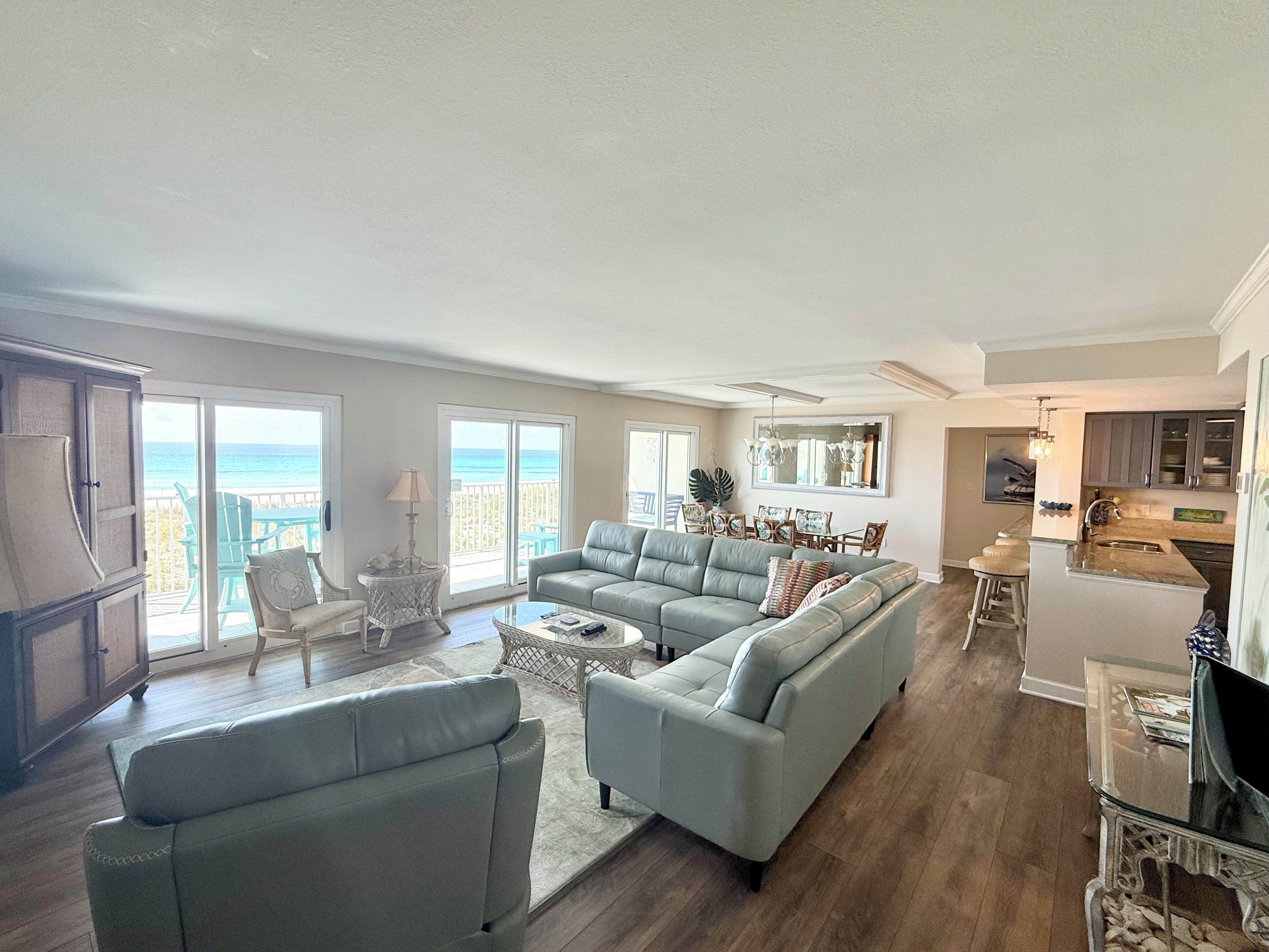 A spacious living area with a large sectional sofa, a dining table, and a kitchen area.