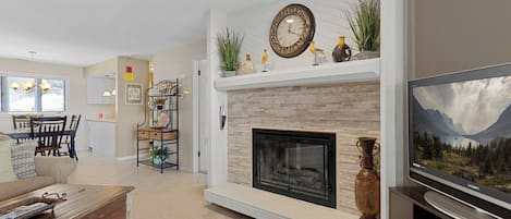 Una sala de estar con chimenea, comedor y televisor.