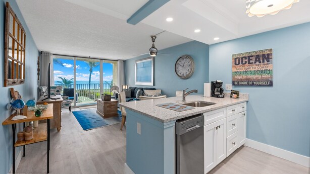 A modern kitchen with a central island, a dining area with a view, and a living space with a large window.