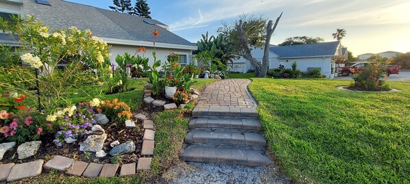 A pathway leading to a house with a garden.