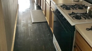 Una cocina con armarios de madera, estufa y lavamanos.