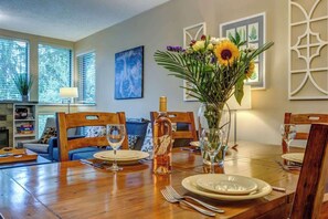 Ein Esstisch, gedeckt mit Tellern, Besteck und einer Blumenvase.