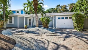 A residential property with a driveway, palm trees, and a garage. - Lantana Cabana 3BR North Clearwater Beach Home (Cleawater)
