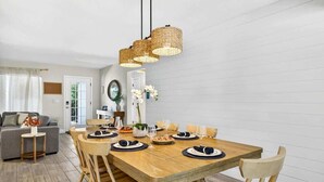 A dining area with a wooden table set for six, surrounded by wooden chairs. - Lantana Cabana 3BR North Clearwater Beach Home (Cleawater)