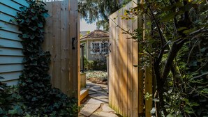 A wooden gate leading to a house with a stone pathway. - La Vignette, Dog Friendly Bungalow Close to the Lakefront (Niagara-on-the-Lake)