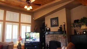 Ein Wohnzimmer mit Kamin, Fernseher und Holzboden.