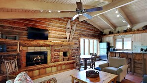 A cozy log cabin interior with a fireplace, wooden furniture, and a dining area. - 🌲Timberline A3E Deluxe 2-Bedroom + Loft ~ 2/bath ~Hot Tub~Pool~WiFi~Ski-in/out~Local Shuttle🌲 (Snowmass Village)