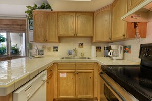 Enjoy cooking in this fully equipped kitchen with a dishwasher, stove, and coffee maker.
