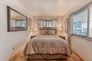 Comfortable bedroom with a large bed, bedside tables, and a large mirror.
