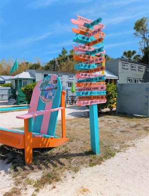 A colorful signpost with directional arrows pointing to various destinations.