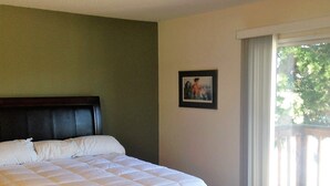 A bedroom with a large bed, a headboard, a framed picture on the wall, and a view of the outdoors through a window. - Large house in Silicon Valley - 40 min from San Francisco near Levi's Stadium (Santa Clara)