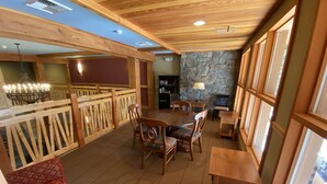 A cozy restaurant with wooden furniture, stone walls, and large windows. - Studio Style Lodging Ski-In/Ski-Out (Whitefish)