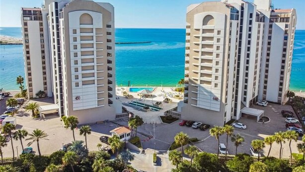 A high-rise hotel with a pool and beach view, featuring multiple floors and a central courtyard.