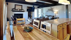 A spacious living area with a wooden dining table, a fireplace, a sofa set, and a kitchen island. - 🌲Timberline D2A Standard 3-Bedroom ~Hot Tub~Pool~WiFi~Ski-in/out~Local Shuttle🌲 (Snowmass Village)