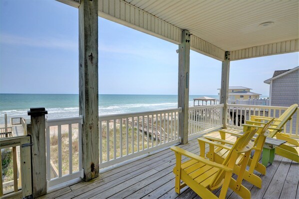 A wooden deck with yellow chairs overlooking the ocean. - Five Bedroom Oceanfront Home - Just Chilln (North Topsail Beach)