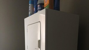 Máquina de lavar compacta, branca, com abertura frontal e painel de controle com botões.