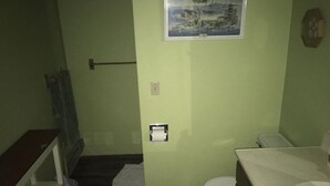 Uma casa de banho pequena com sanita, lavatório e zona de duche.