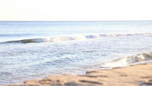 Ein Strand mit sanft brandenden Wellen.