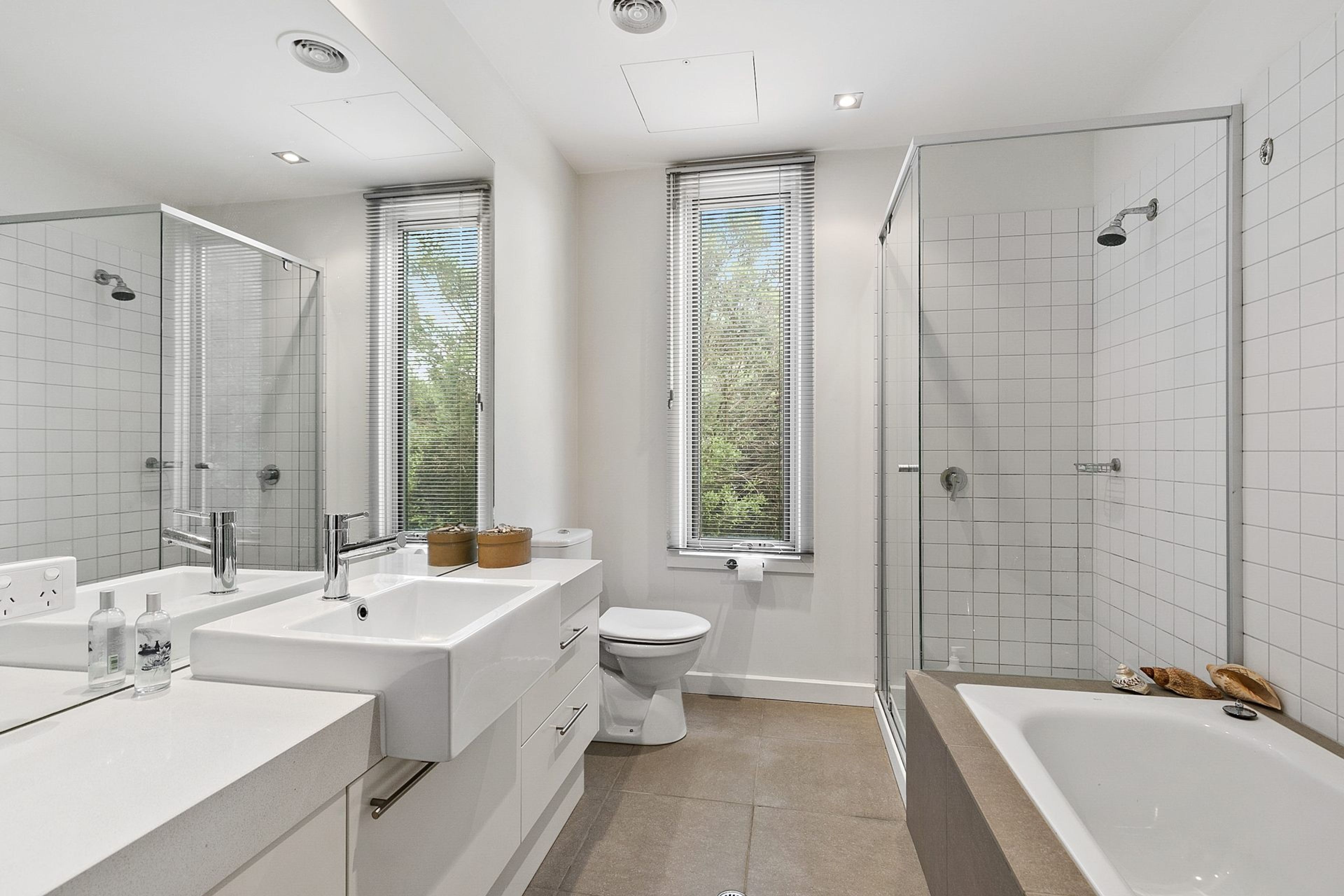 Un bany modern amb banyera, dutxa, vàter i un lavabo.