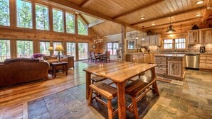 Ein geräumiges Cabin-Interieur mit Essbereich, Küche und Sitzgelegenheit mit großen Fenstern.