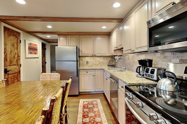 A kitchen with wooden cabinets, a stainless steel refrigerator, a stove, and a microwave. - 🌲Timberline D3D Deluxe 2-Bedroom + Loft ~ 3/bath ~Hot Tub~Pool~WiFi~Ski-in/out~Local Shuttle🌲 (Snowmass Village)