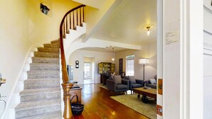 A spacious living area with a wooden staircase, a fireplace, and a cozy seating arrangement. - Beautiful Magnolia House in Napa Valley! (Napa)