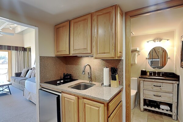 A compact kitchen with wooden cabinets, a stainless steel sink, and a built-in oven. - 🌲Timberline 318 Studio Deluxe ~ Hot Tub~Pool~WiFi~Ski-in/out~Local Shuttle🌲 (Snowmass Village)