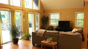 A living room with a sofa, a television, and potted plants. - Bedrooms 4, Bathrooms 2, Sleeps 8 (Linden)