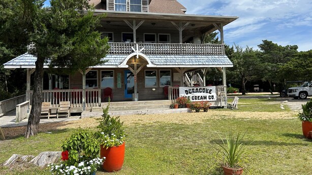 A two-story building with a porch and a sign for Ocracoke Cream Co. - Harbor II: Pet friendly, views of both the Lighthouse and Silver Lake. (Ocracoke)