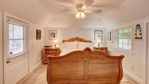 A bedroom with a wooden bed, a ceiling fan, and two bedside tables with lamps.